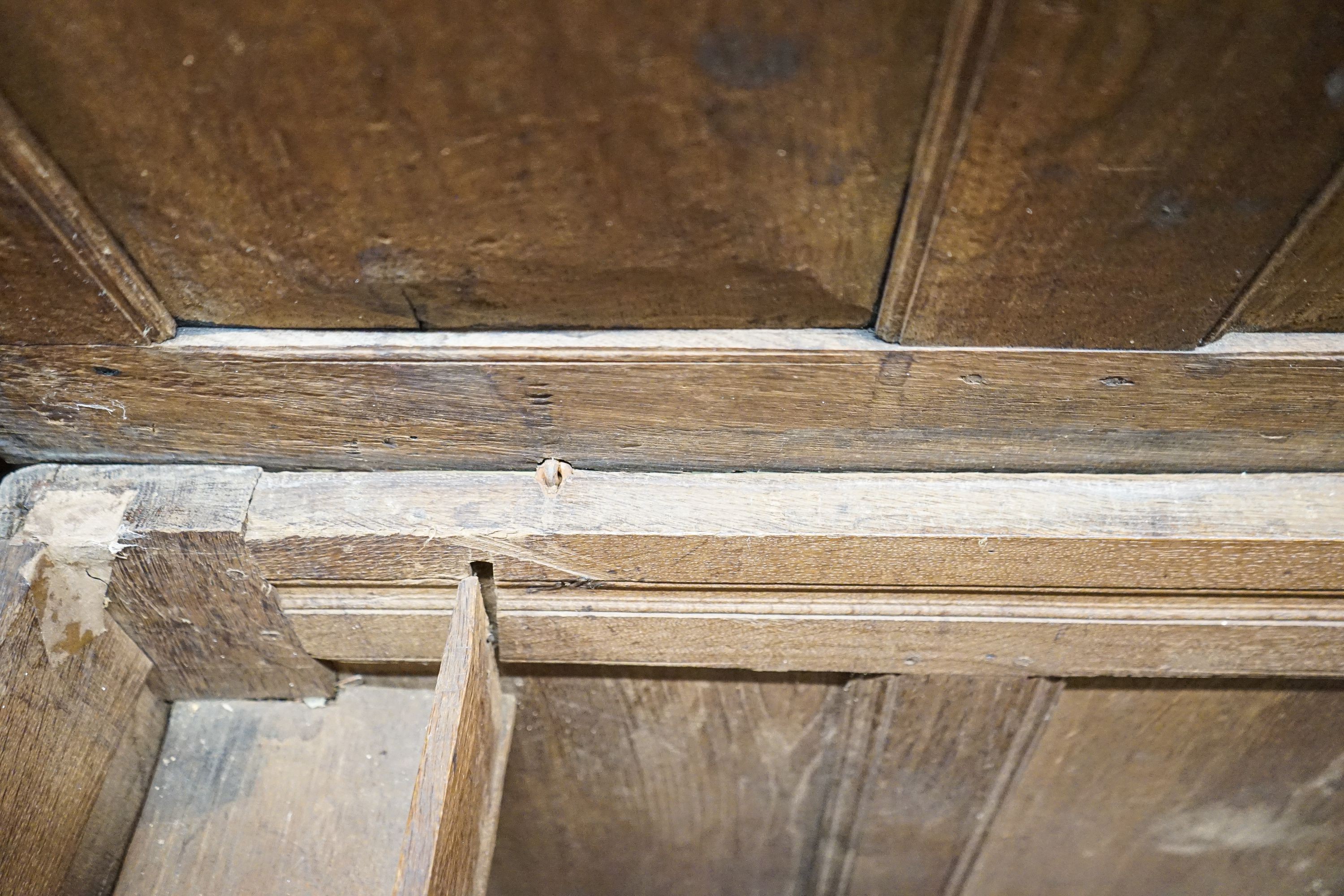 An early 18th century oak coffer, with four panel top and later carved and applied decoration, width 152cm, depth 63cm, height 74cm